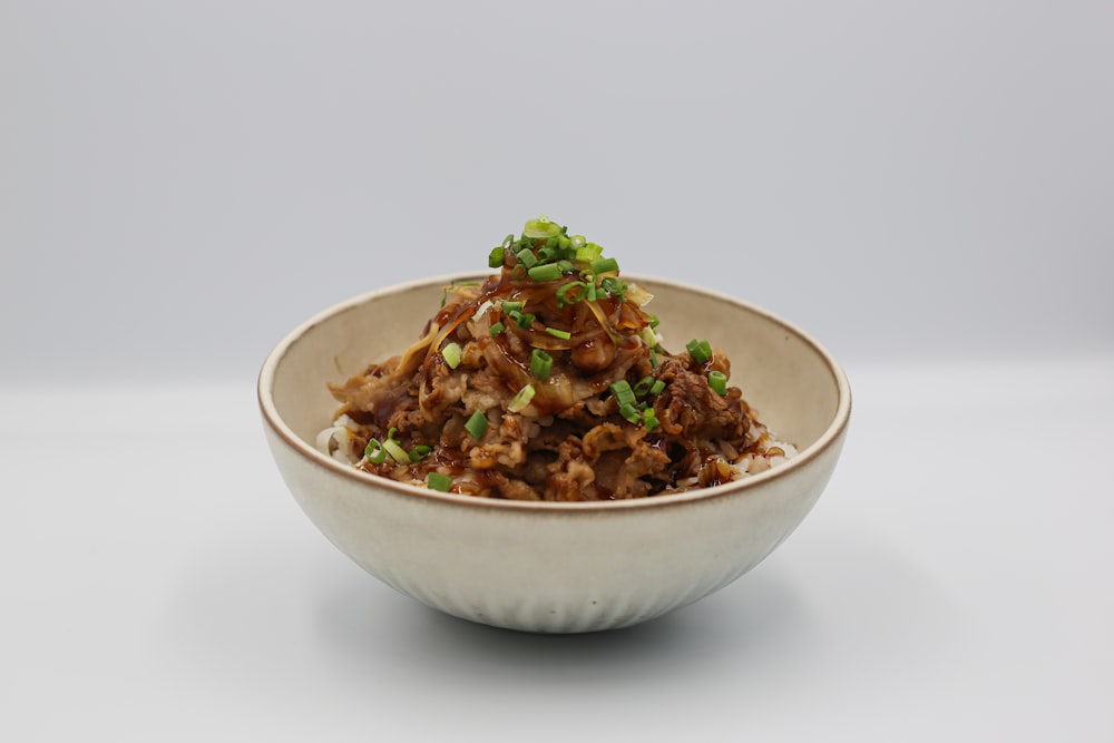 a white bowl filled with food on top of a table