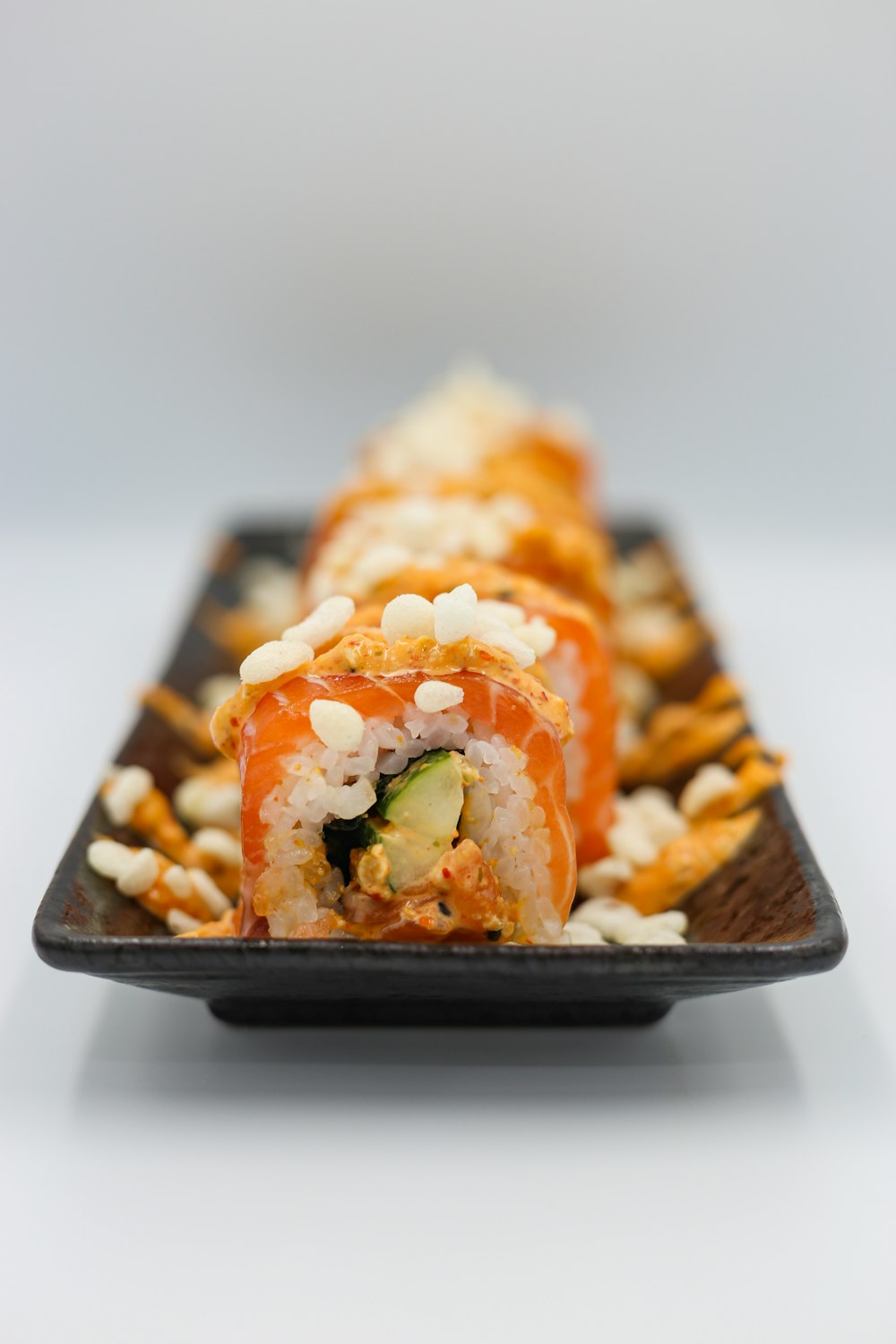 a sushi roll is on a black plate