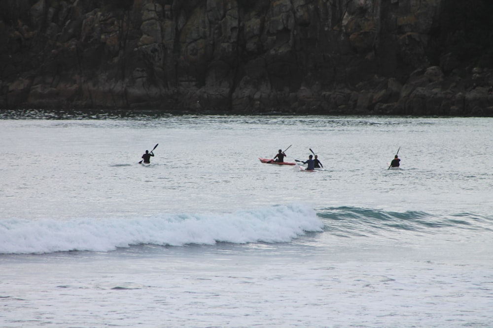 a group of people riding paddle boards on top of a wave