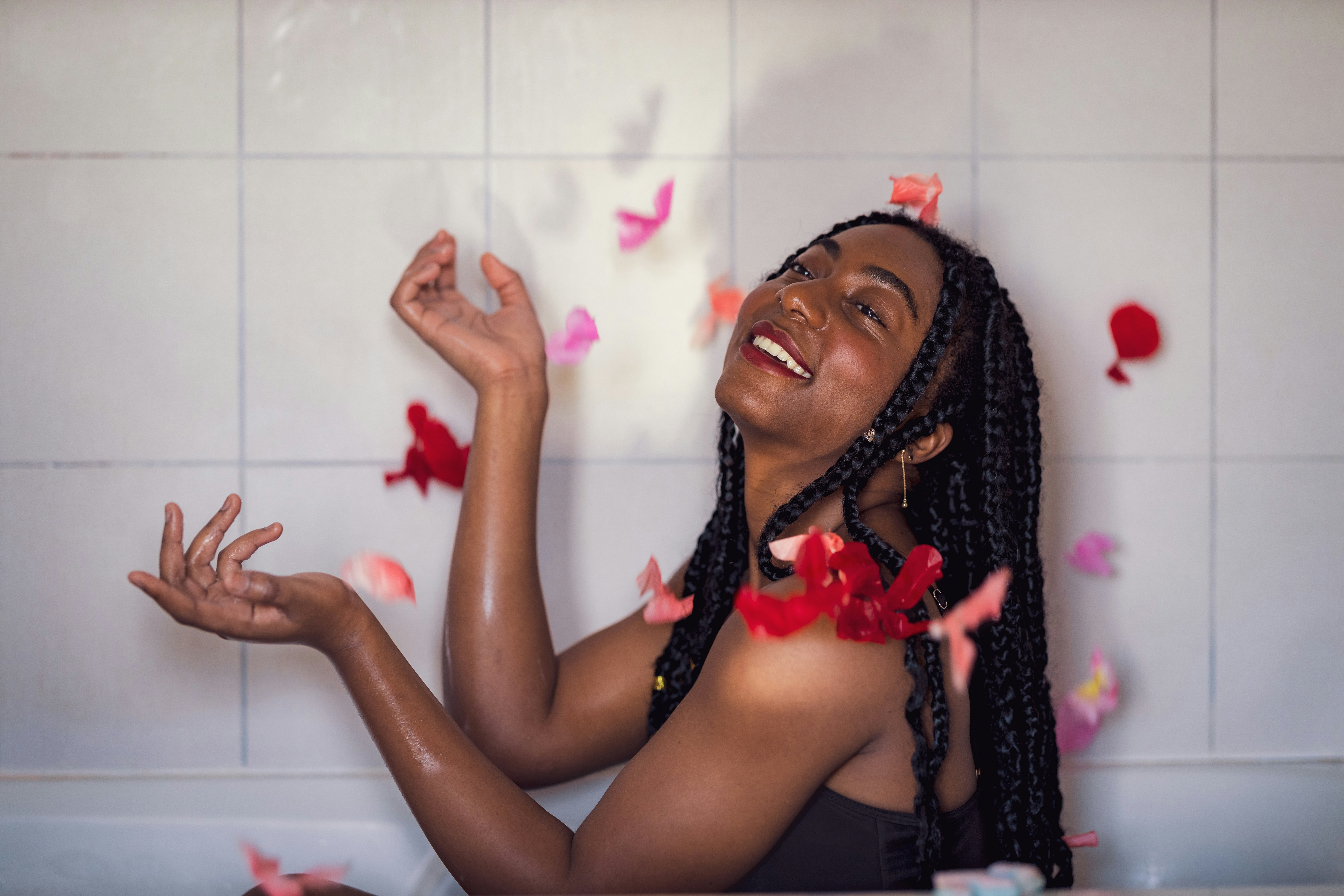 a woman sitting in a bathtub surrounded by confetti