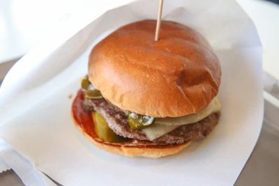 Spicy jalapeño smash burger with fresh jalapeños and spicy mayo dripping off the sides.