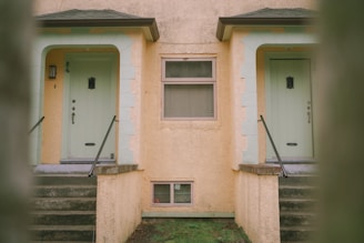 a yellow building with two doors and a window