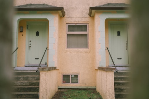 a yellow building with two doors and a window