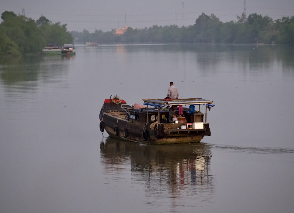 a man standing on a boat in the middle of a lake