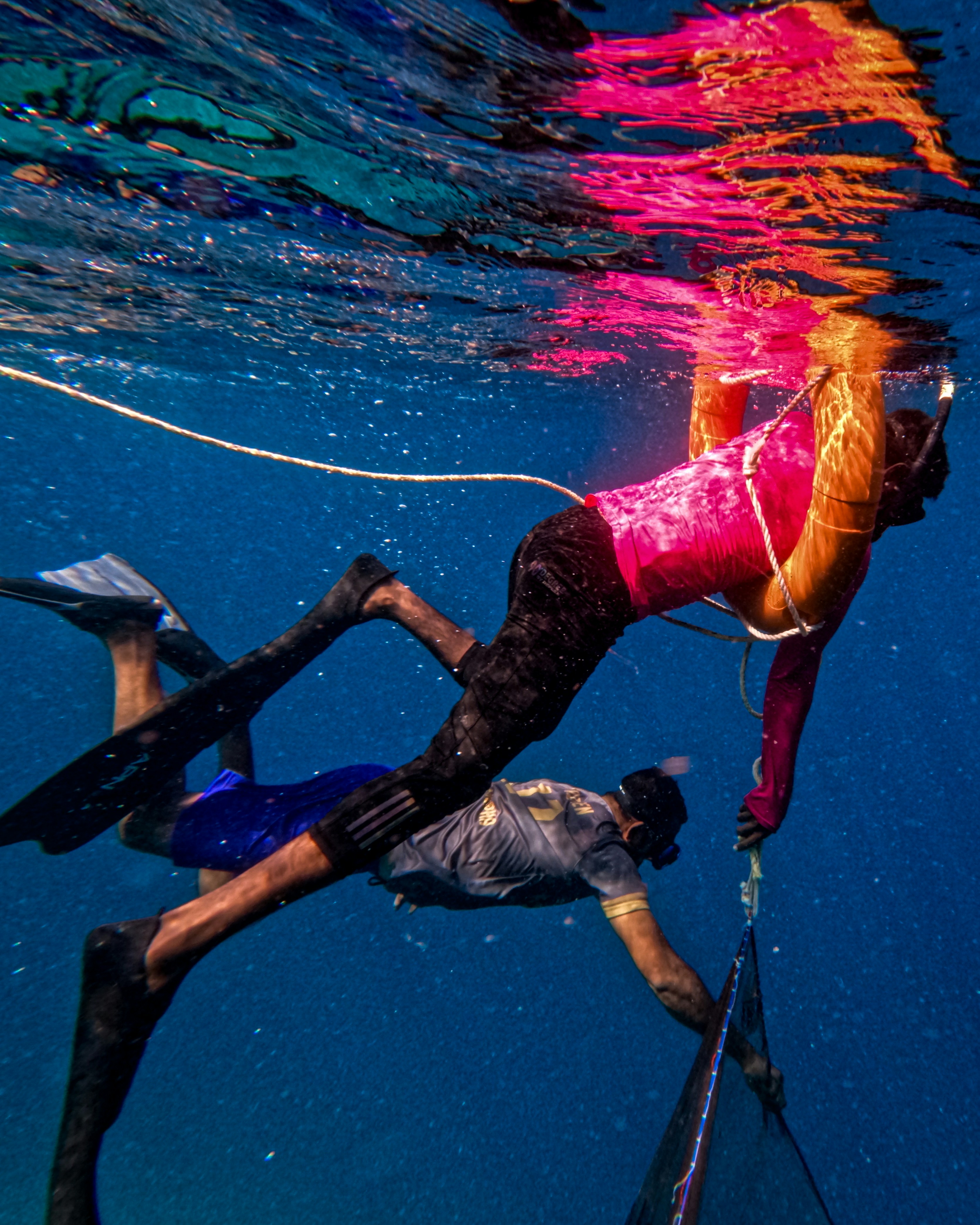 a couple of people riding skis under water