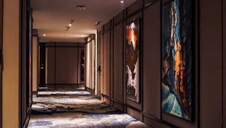 Elegant, dimly lit hallway with deep charcoal walls and soft recessed lighting conveying calm sophistication.