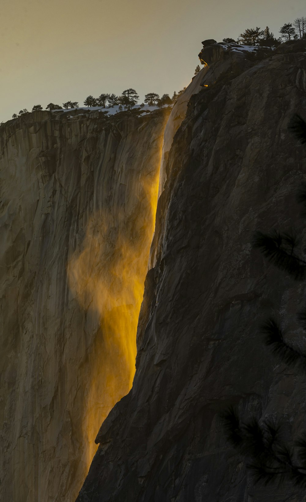 a very tall cliff with a waterfall coming out of it