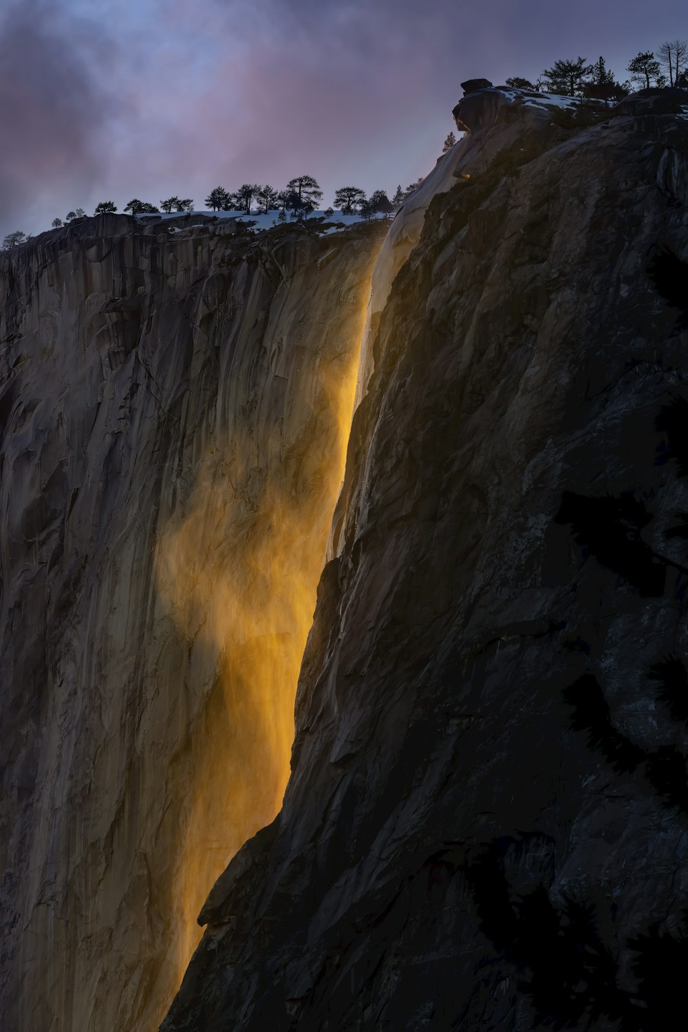 una grande cascata è illuminata dalla luce del sole