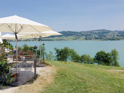 Outdoor seating area overlooking lush greenery and a glimpse of Pantai Timur beach.