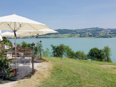 Outdoor seating area with colorful umbrellas beside the shimmering waters of Tattershall Lakes.