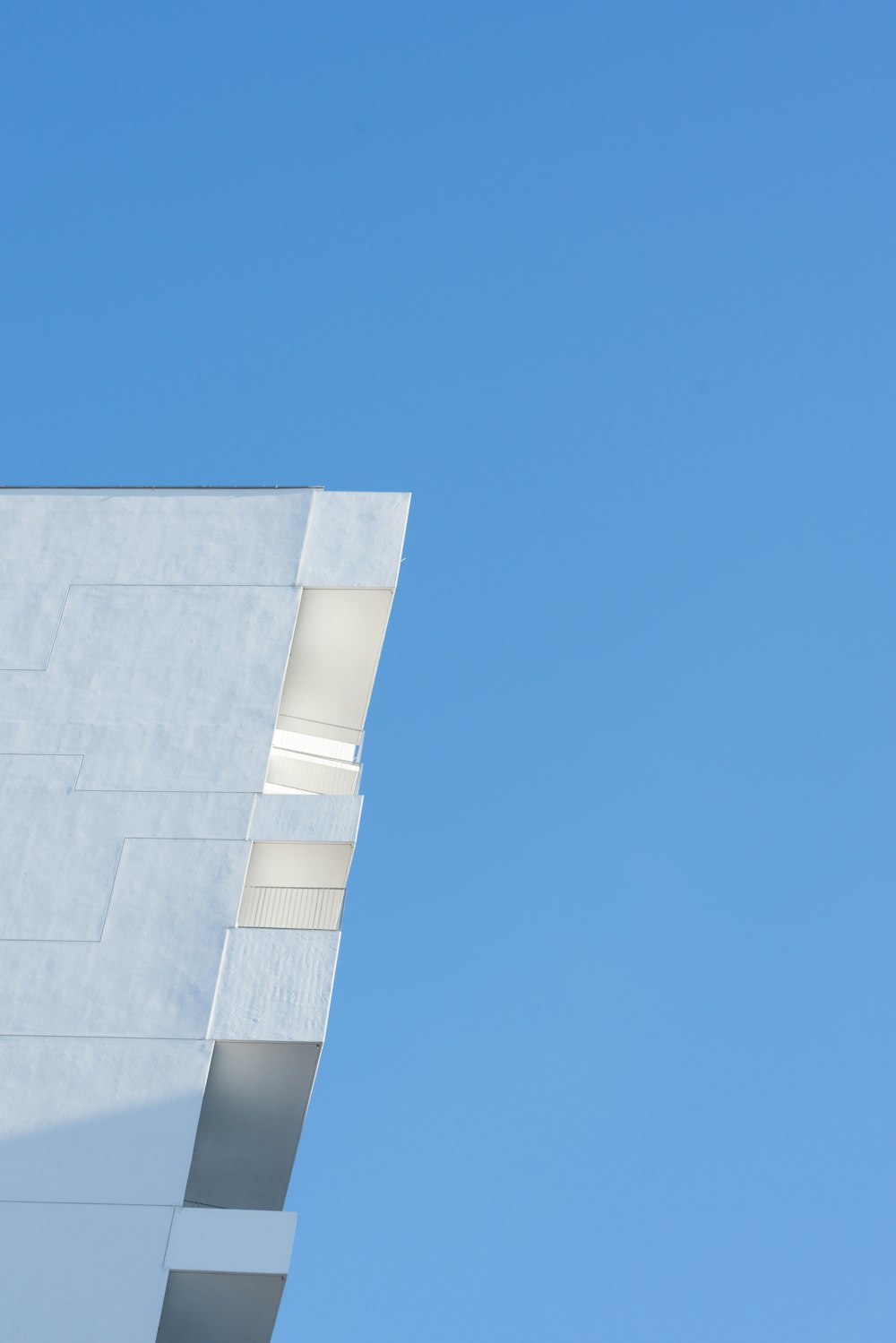 a plane flying in the sky over a building