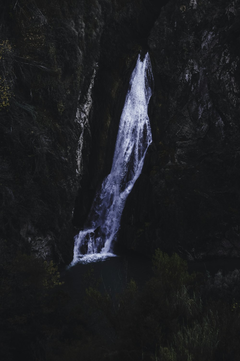 a small waterfall in the middle of a forest