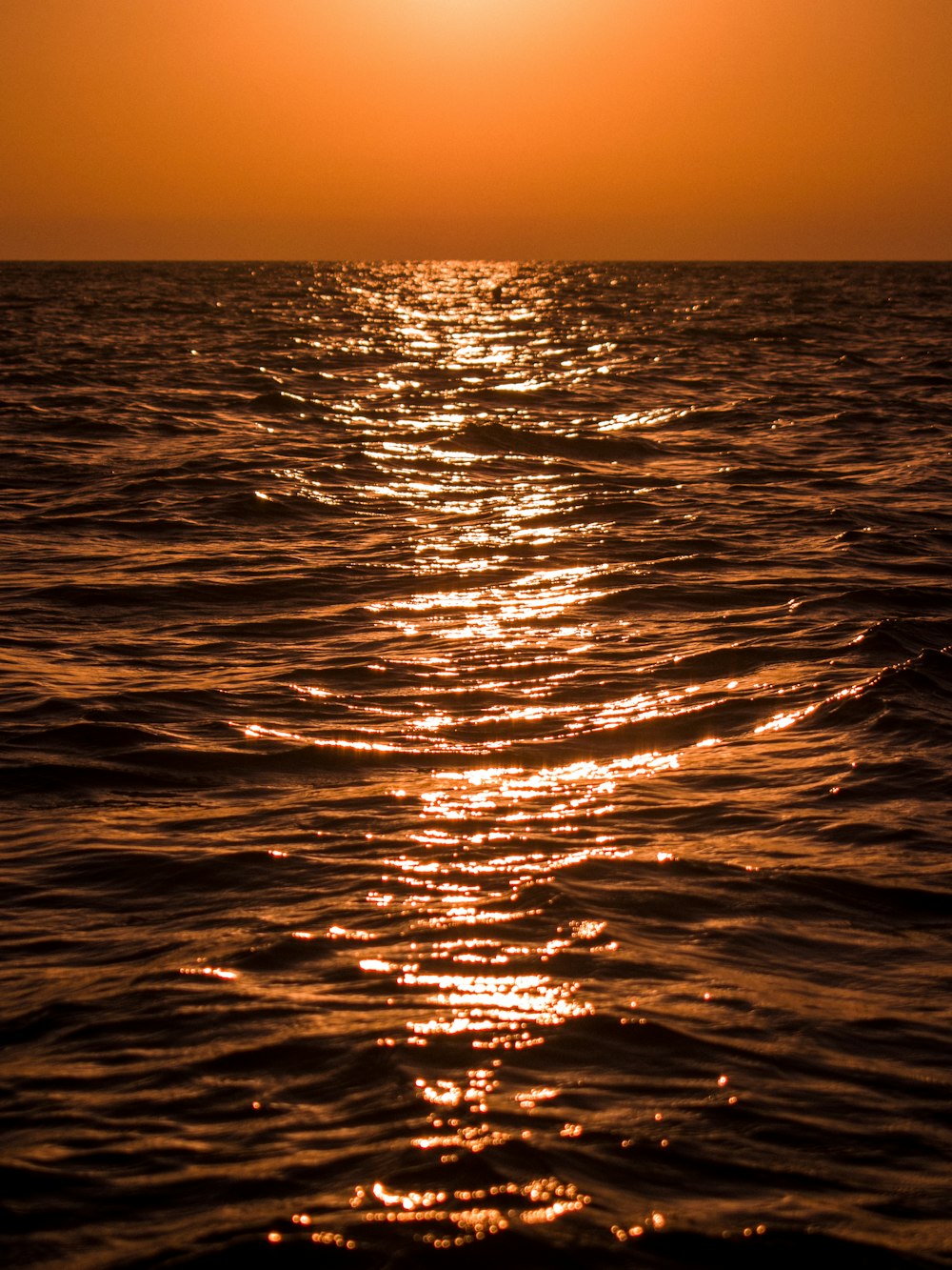 the sun is setting over the ocean water