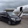 A sleek black Mercedes Vito minivan parked by a sunny Bodrum airport terminal.