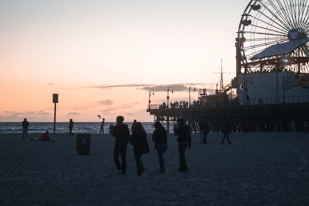 a group of people standing on top of a sandy beach