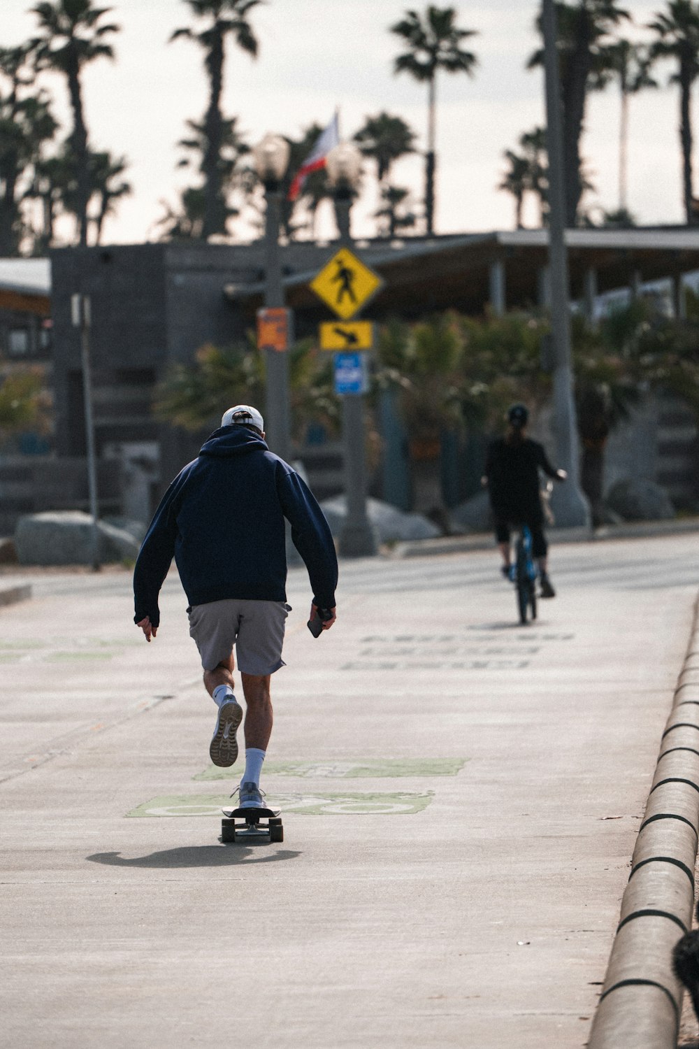 a man riding a skateboard down a sidewalk