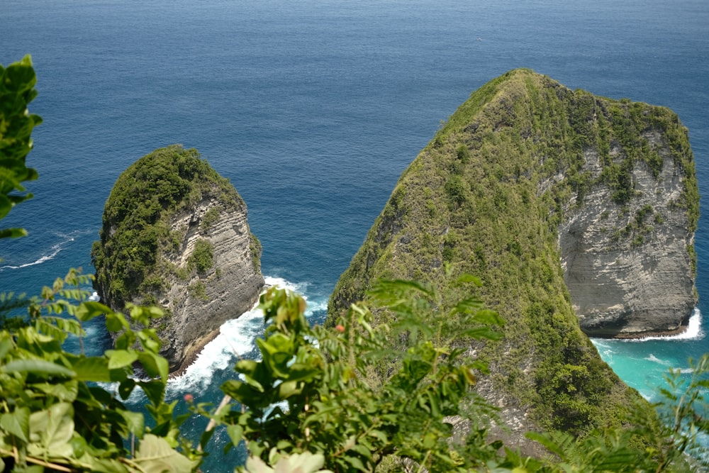 a couple of large rocks sitting on top of a lush green hillside