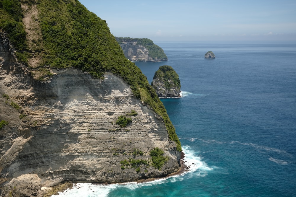 a large body of water next to a lush green hillside