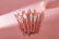 A set of colorful makeup brushes neatly arranged on a marble countertop.