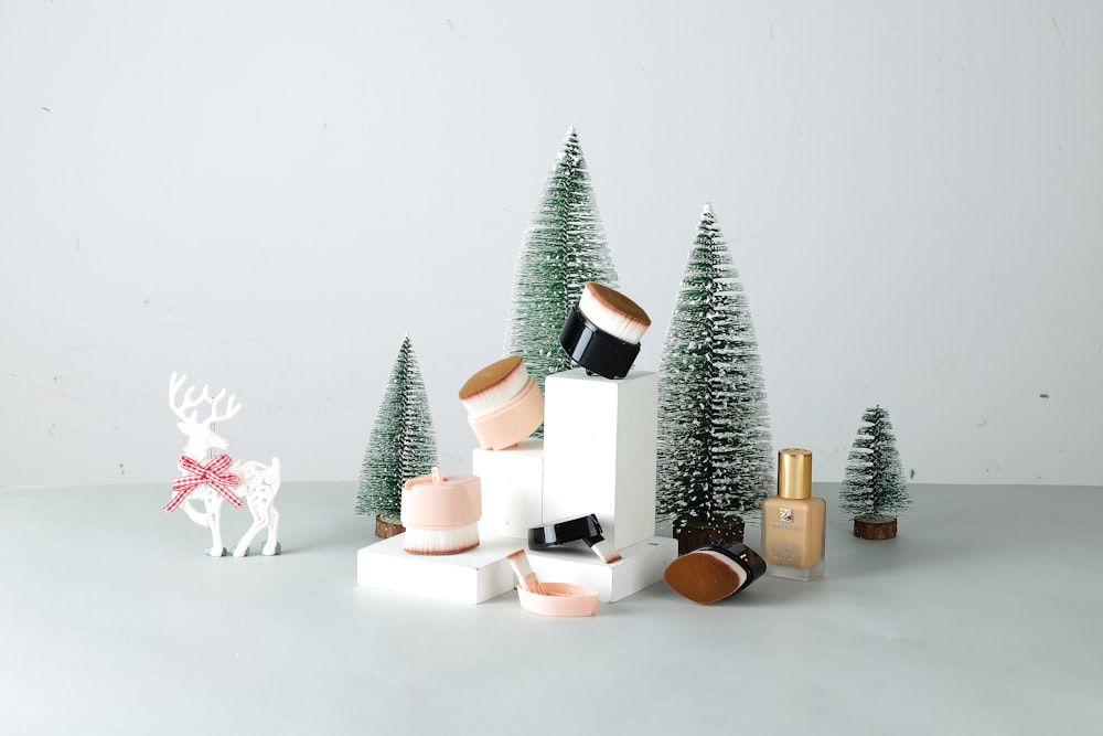 a white table topped with christmas decorations and trees