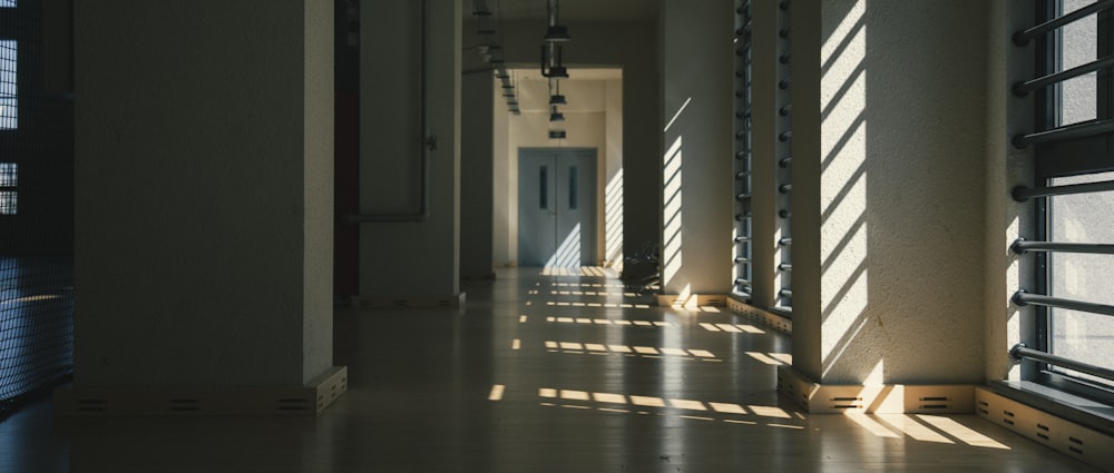 a long hallway with a light coming through the windows