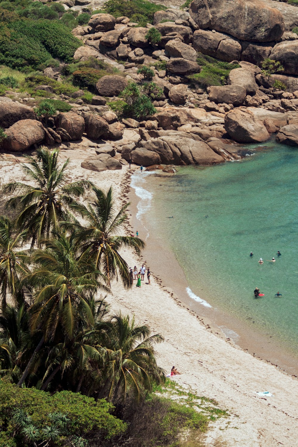 a beach with people swimming in the water