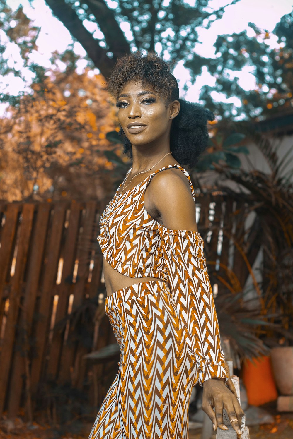 a woman in an orange and white dress posing for a picture