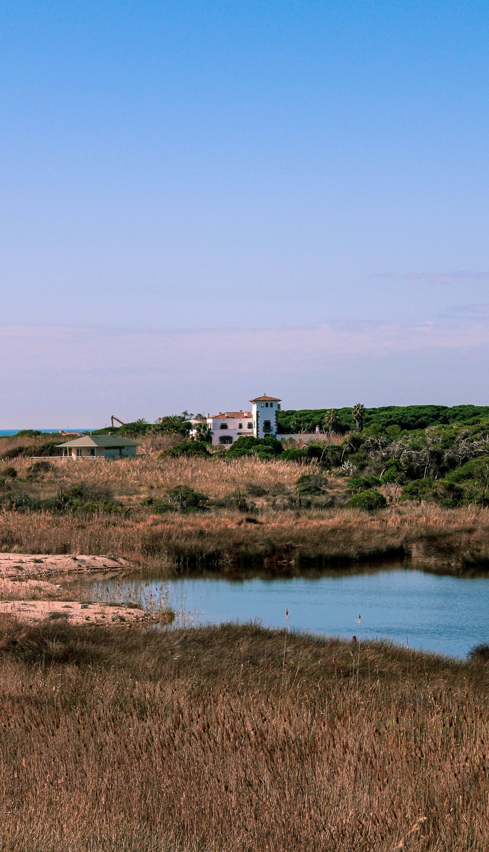 a large body of water sitting in a dry grass field