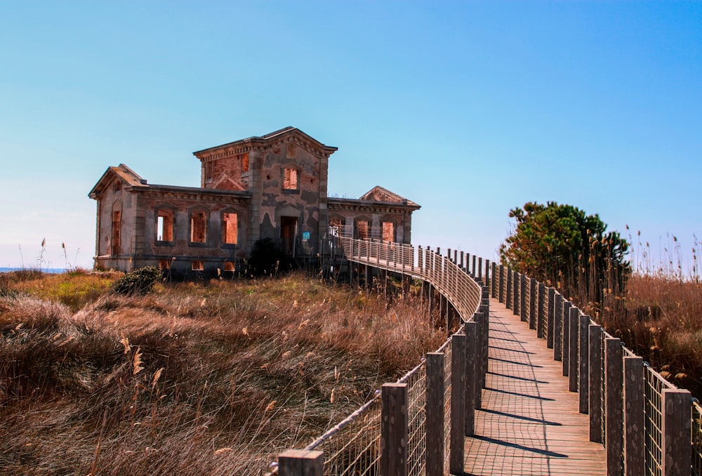 a wooden walkway leading to an old abandoned house