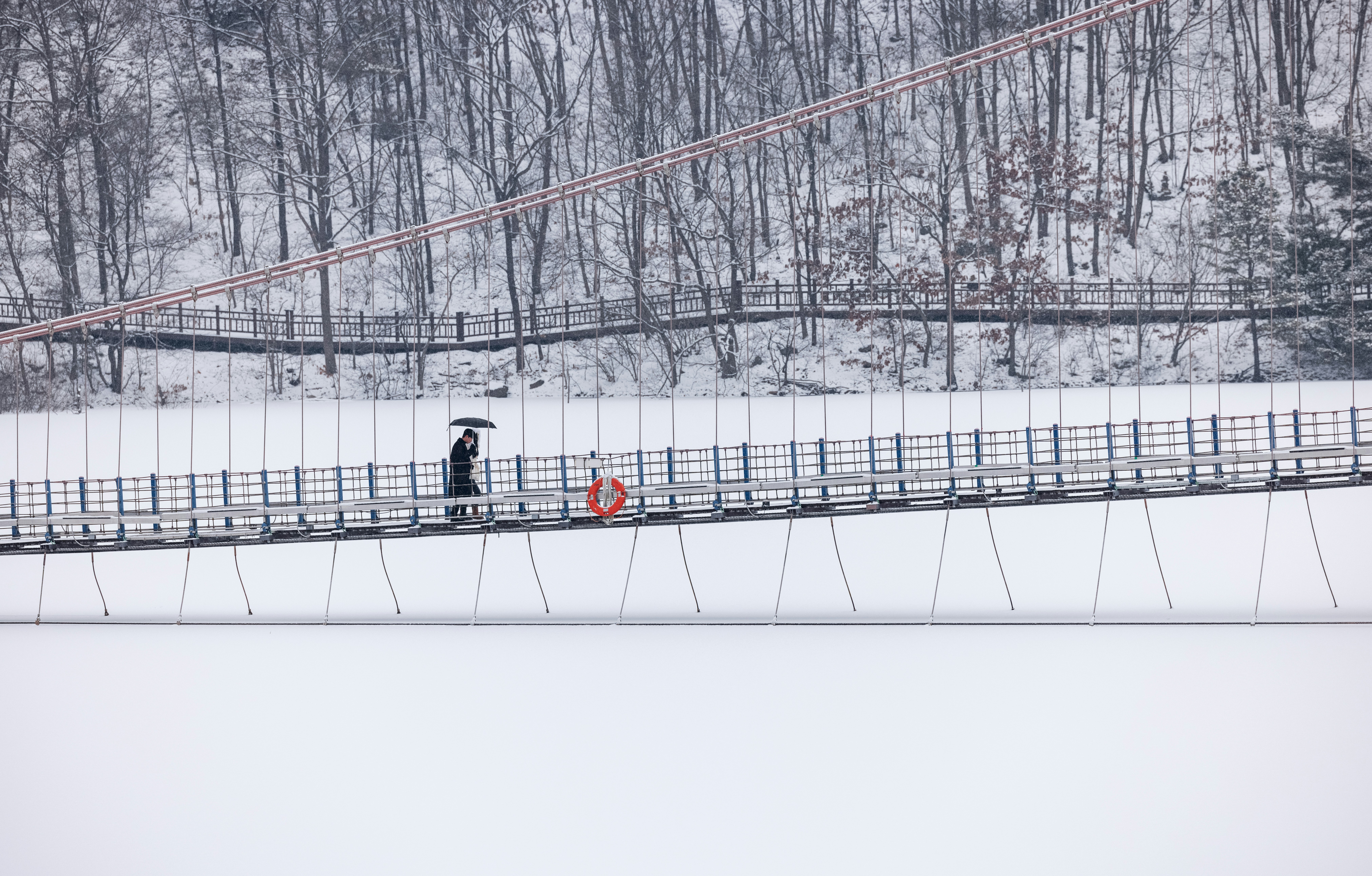 Two people walking across a bridge in the snow photo – Free Suspension ...