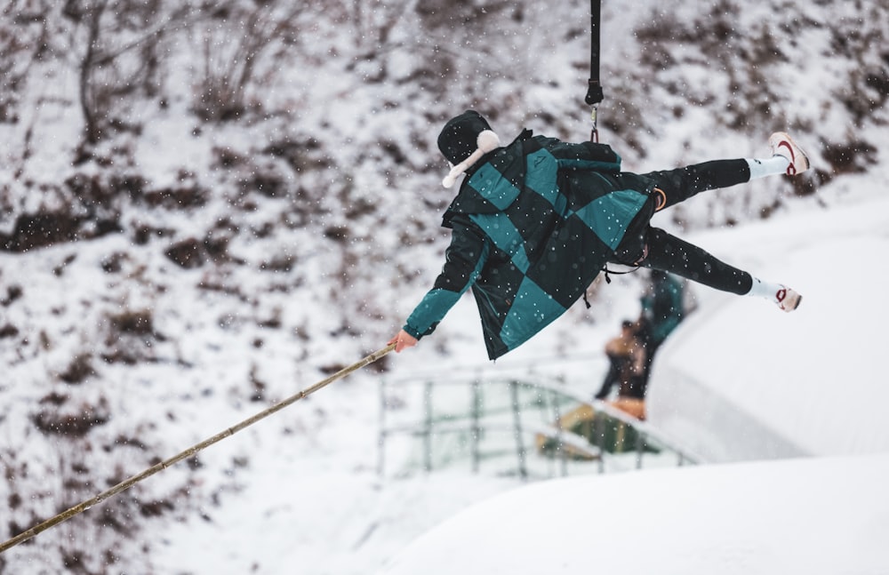 a person on skis in the air above a snowy hill