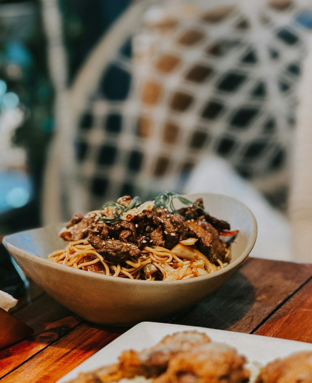 a bowl of food sitting on top of a wooden table