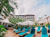 a group of lounge chairs sitting on top of a wooden deck