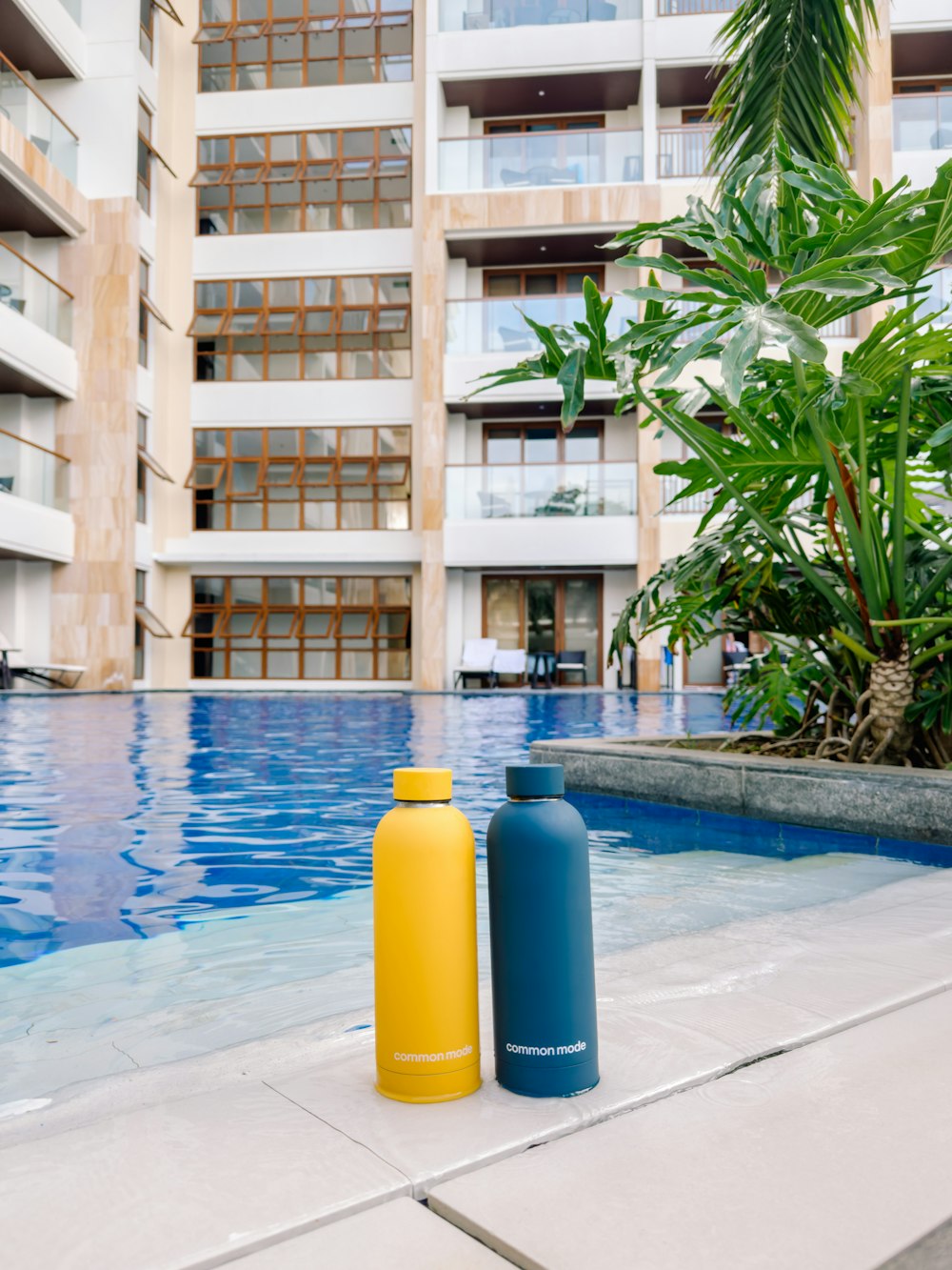 two water bottles sitting next to a swimming pool