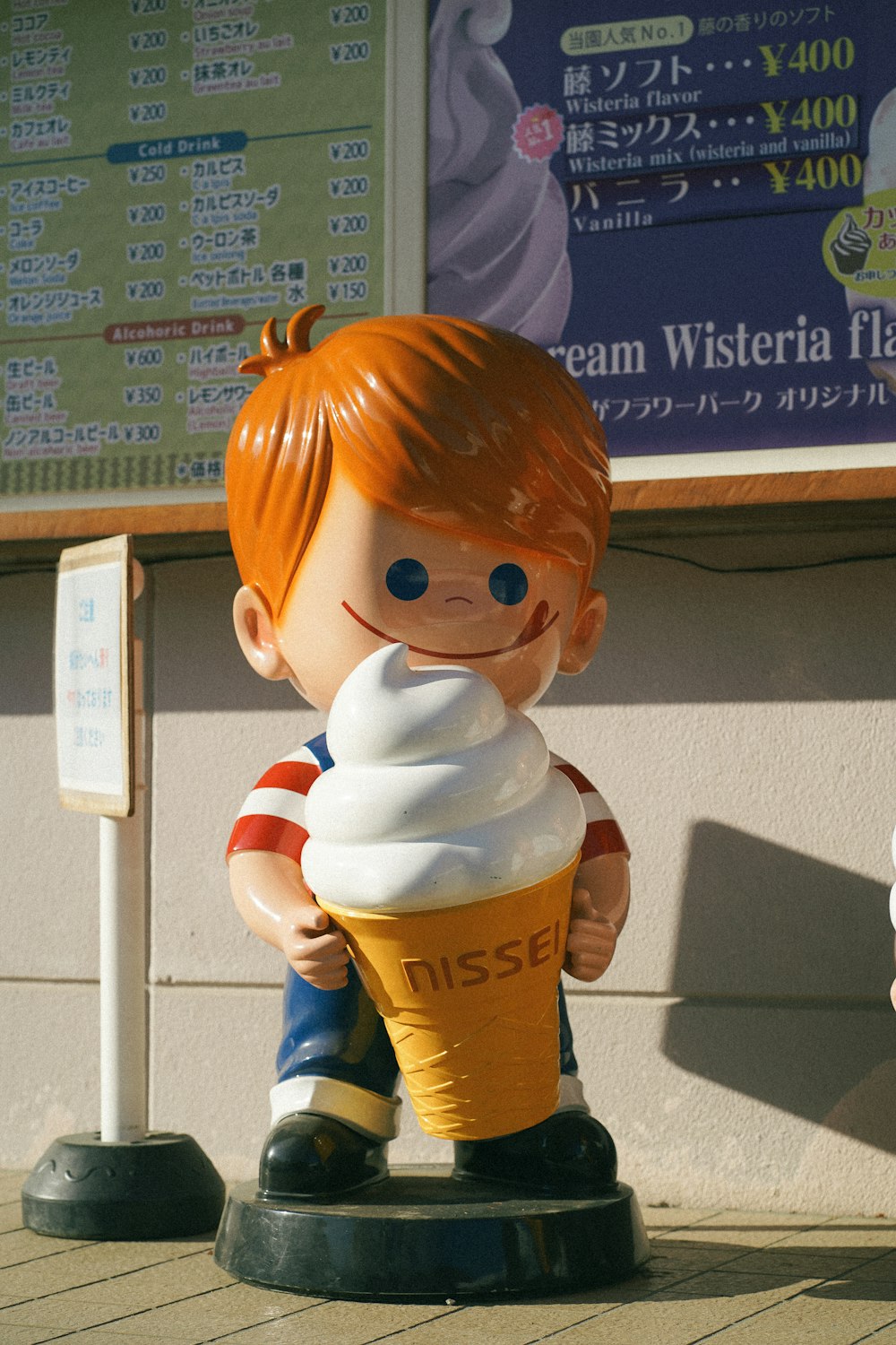 Une statue d’un garçon tenant une tasse de crème glacée