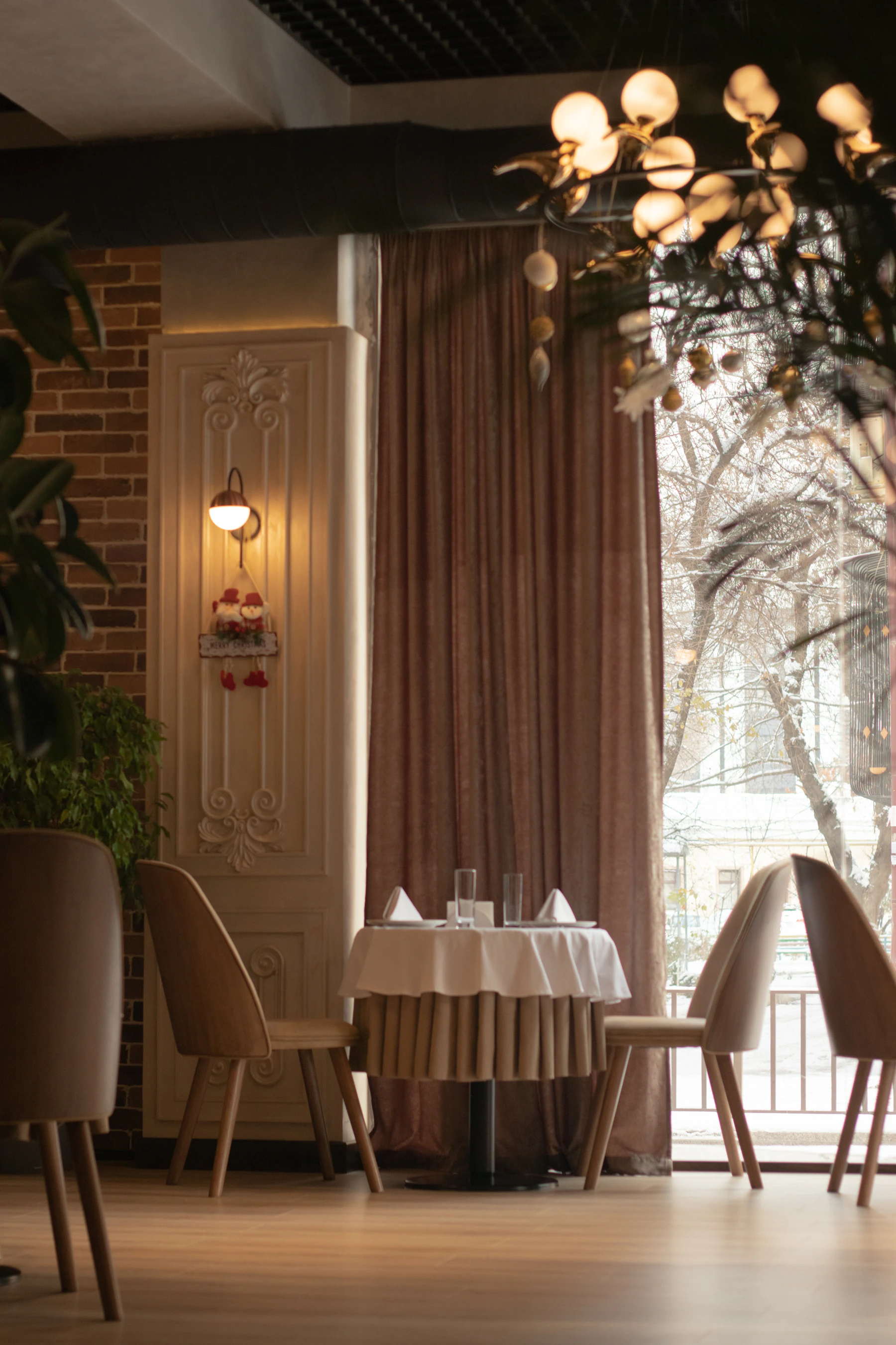 Sala da pranzo elegante illuminata dalla luce del giorno, tavolo apparecchiato di bianco accanto a una grande vetrata