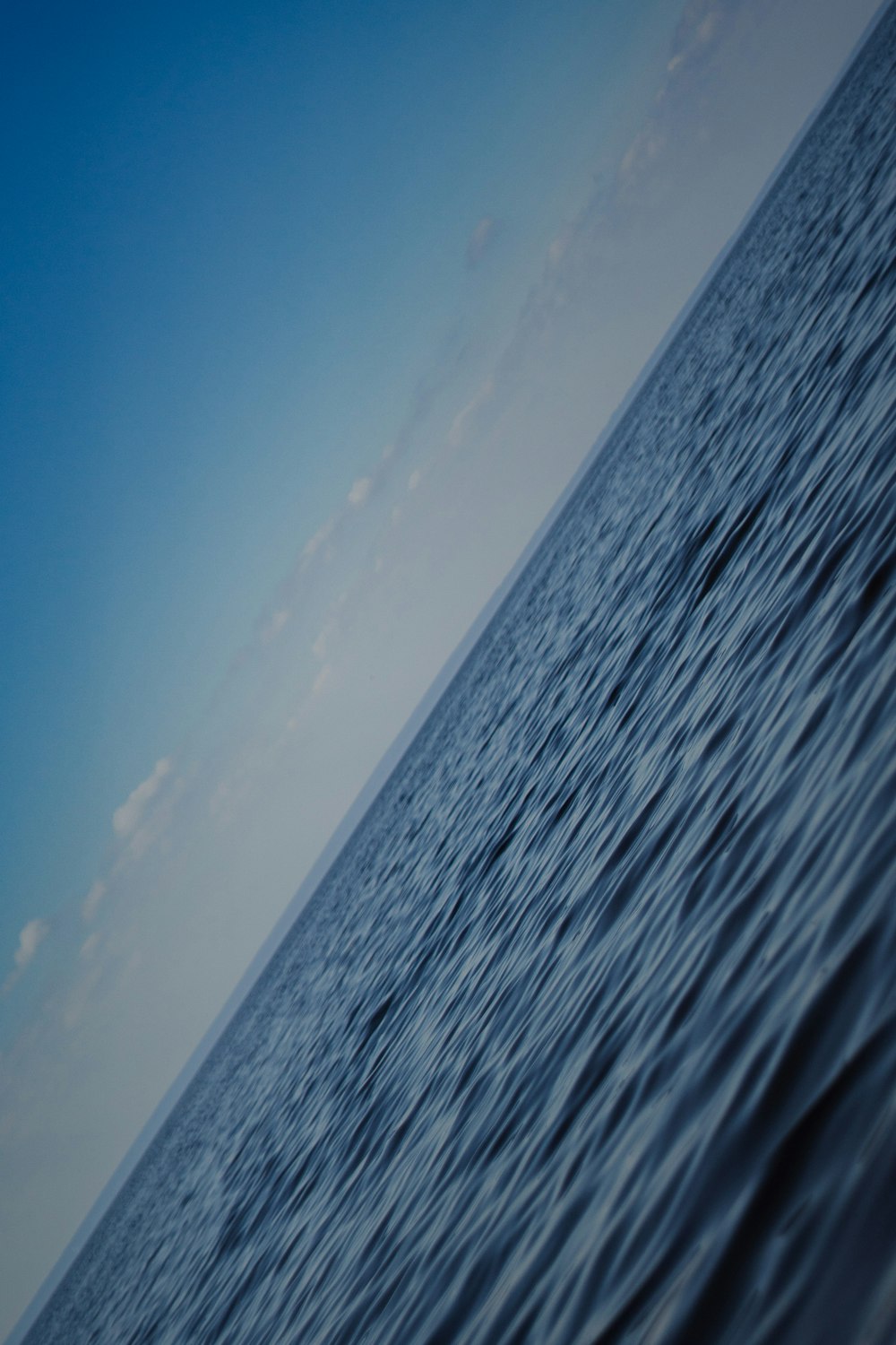 a large body of water with a sky in the background