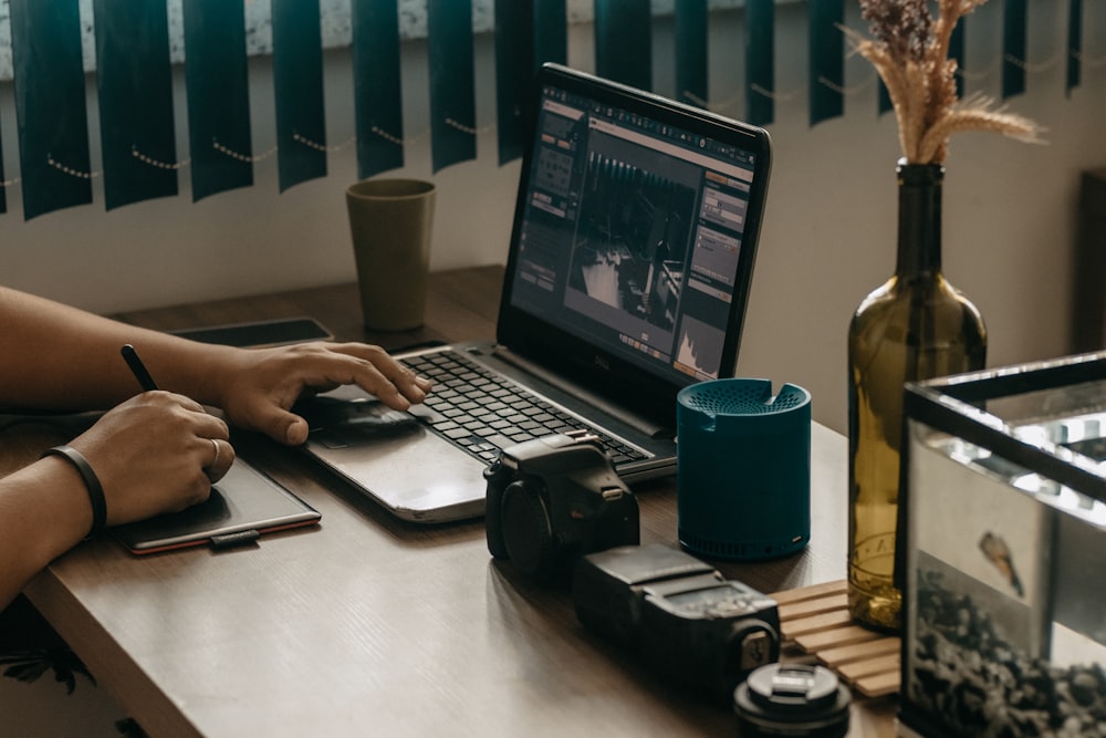 a person sitting at a desk with a laptop and a camera