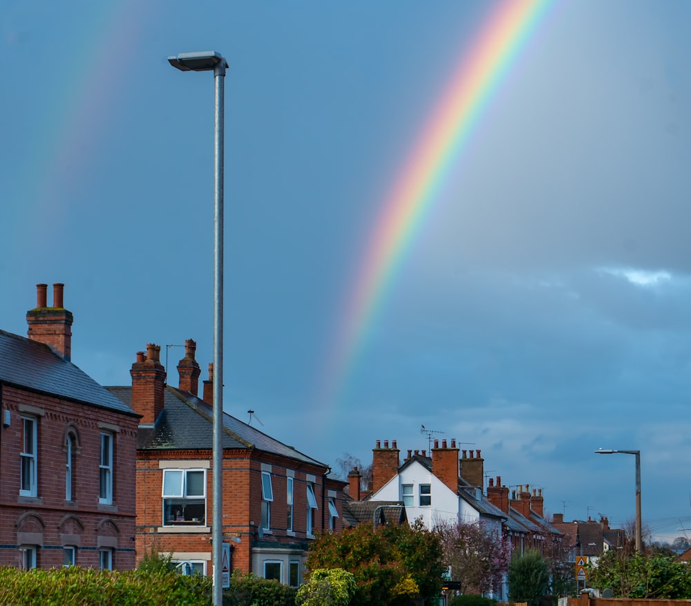 a double rainbow in the sky over a row of houses