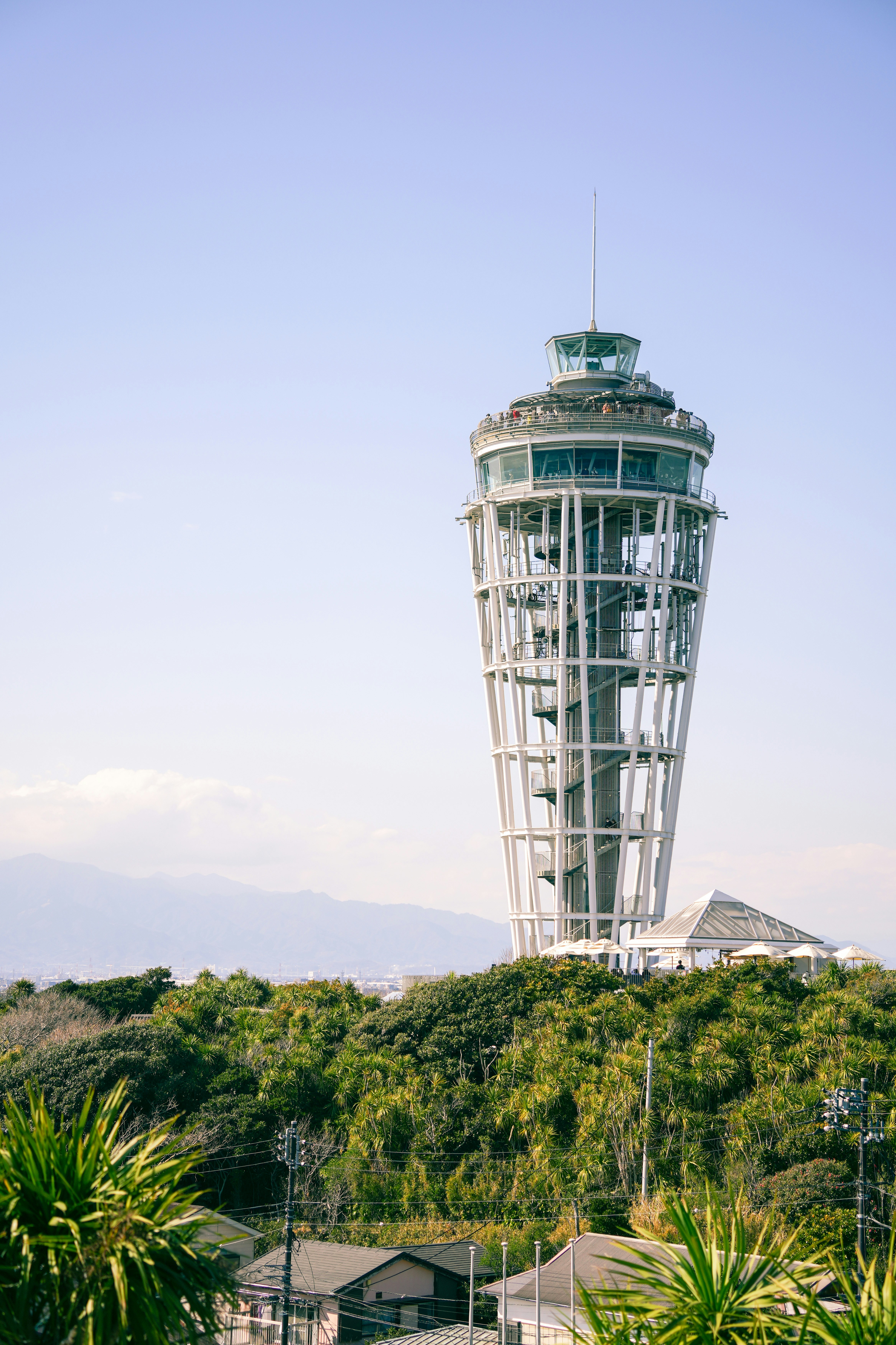 a very tall tower sitting above a lush green forest
