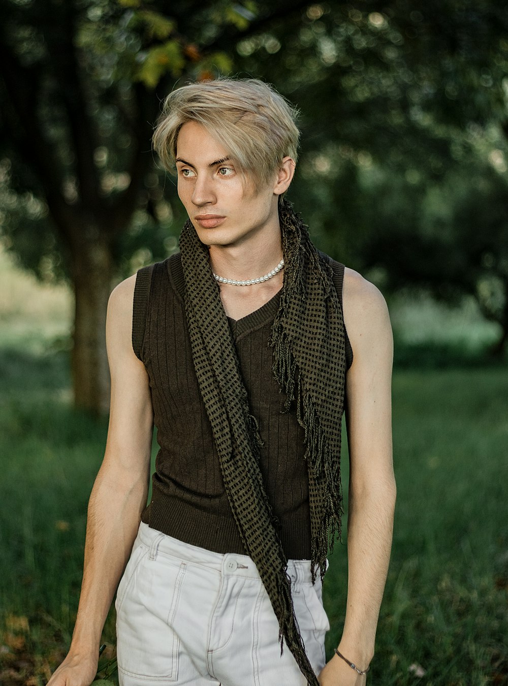 a young man with blonde hair wearing a scarf