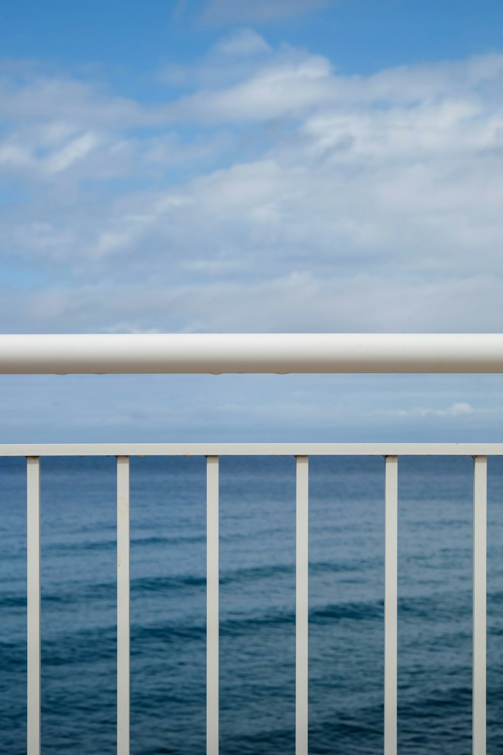 a person standing on a balcony next to the ocean