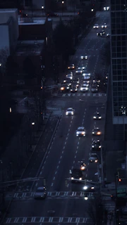 City street at dusk with multiple vehicles highlighted by satellite tracking signals.