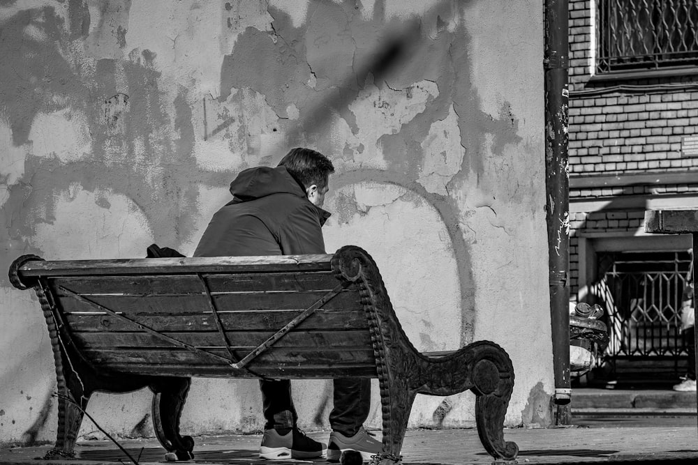 a man sitting on a bench in front of a building