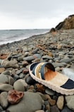 a pair of shoes sitting on top of a rocky beach