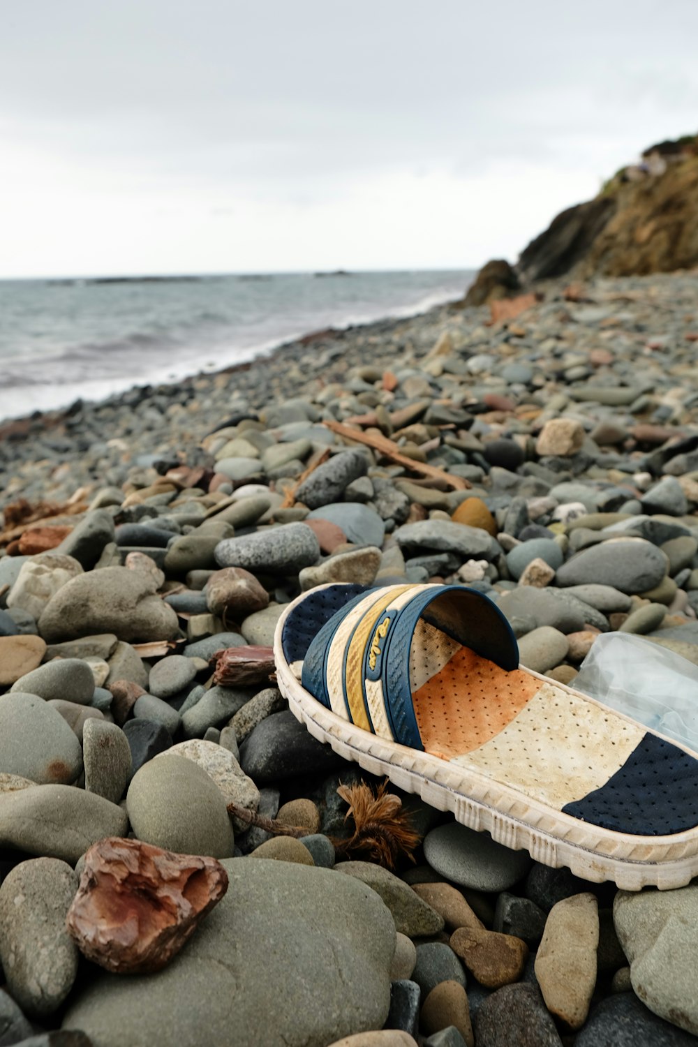 a pair of shoes sitting on top of a rocky beach