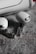 Two wireless earbuds with a sleek and modern design are lying on a textured gray surface. The earbuds feature a transparent section revealing internal components, adding a futuristic element to their appearance.