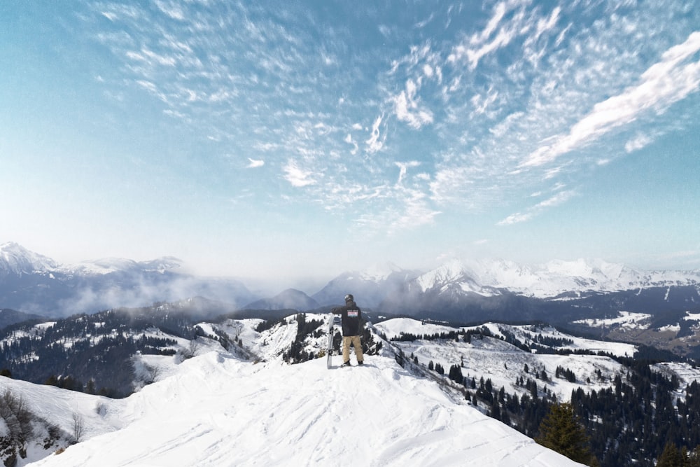 a man standing on top of a snow covered mountain