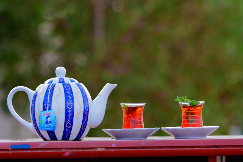 a tea pot and two cups on a table