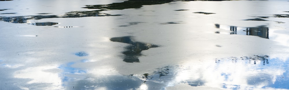 a reflection of a building in a puddle of water